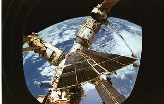 View of the Mir space station modules (Base Block, Kvant, Spektr and solar arrays) as seen from the Spacehab viewing portal. 